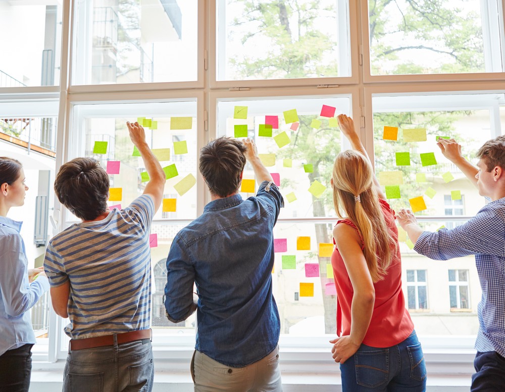 Menschen kleben Zettel an Fenster (Foto: adobe.stock.com - Robert Kneschke)